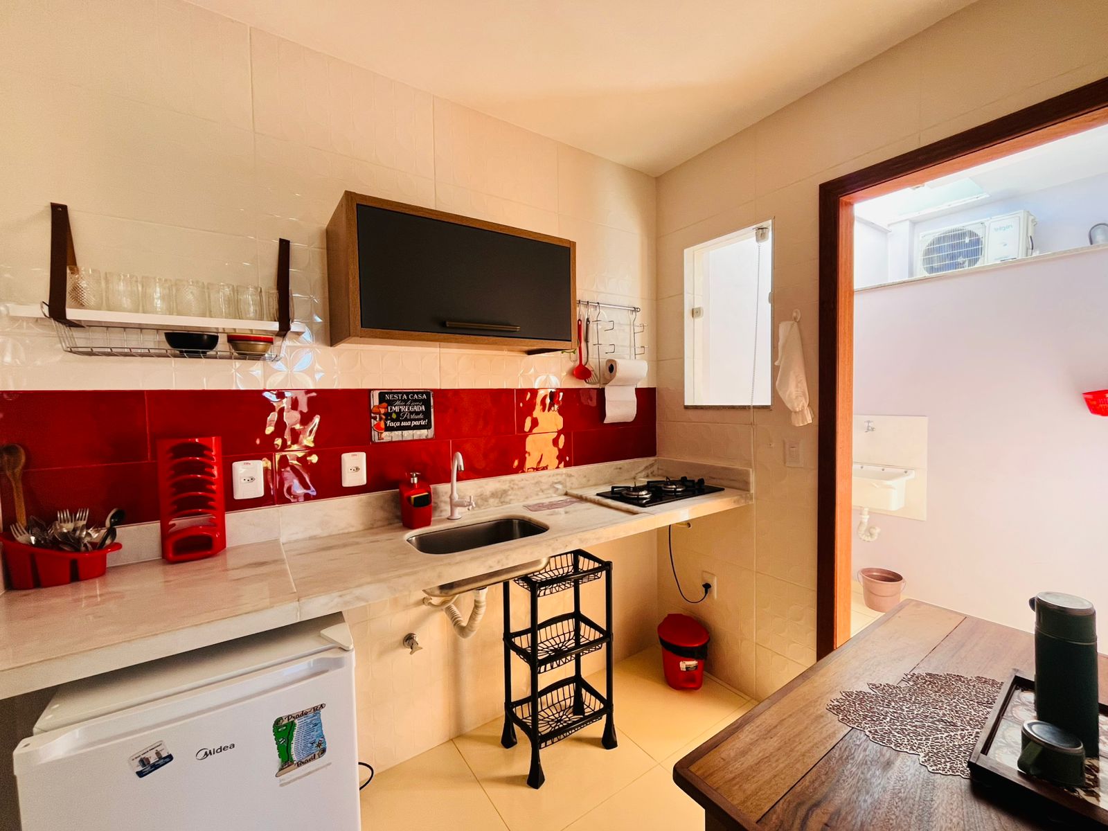 Cozinha de apoio com bancada, cooktop e mesa